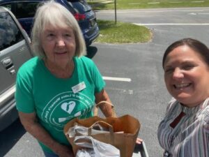 Member Pat Wagner delivering cart full of school supplies 