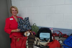  Club President Elayne Bassinger displays donated handbags and backpacks