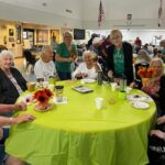 Members assisting seniors with craft project