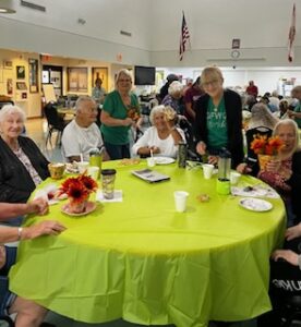 Members assisting seniors with craft project