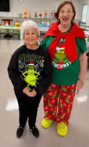 Christmas in July event chair, Darlene Choe (on right) with member, Dee Knerr, model their Grinch Inspired clothing.